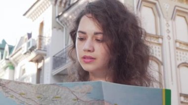 Mutlu genç kadın bir harita tutan kameraya gülümseyen