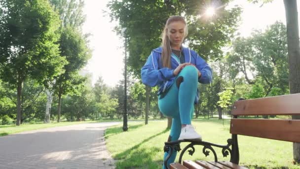 Привлекательная спортсменка растягивается на открытом воздухе в парке — стоковое видео