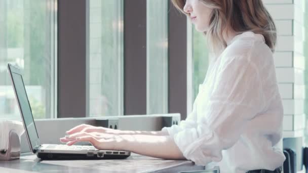 咖啡店里一名在笔记本电脑上工作的妇女的滑动照片 — 图库视频影像
