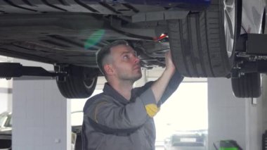 Oto tamircisi bir asansörlü arabanın SUV süspansiyon kontrol sürgülü çekim