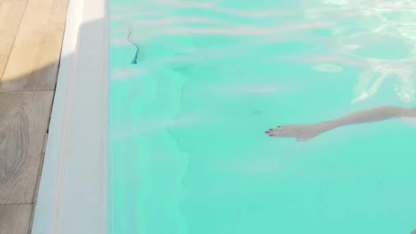 Mujer joven nadando en la piscina en un cálido día de verano — Vídeos de Stock