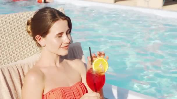 Hermosa mujer feliz disfrutando de beber cóctel en la piscina — Vídeos de Stock