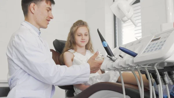 Dentista parlando con il suo piccolo paziente attenzione selettiva sugli strumenti dentali in primo piano — Foto Stock