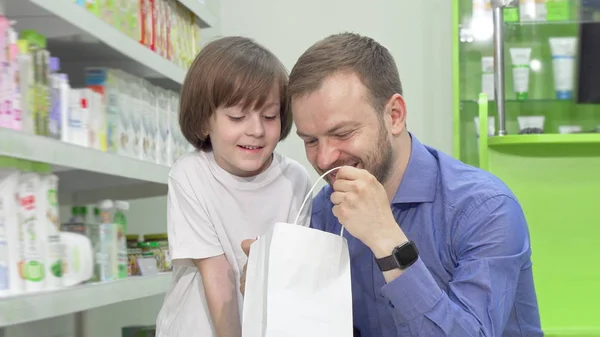 Mature man shopping at drugstore with his little son — Stock Photo, Image