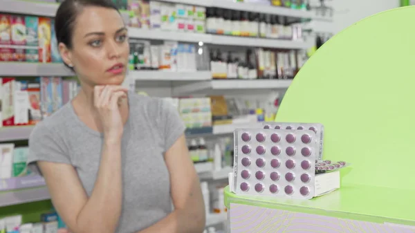 Beautiful woman choosing vitamins at the drugstore — Stock Photo, Image