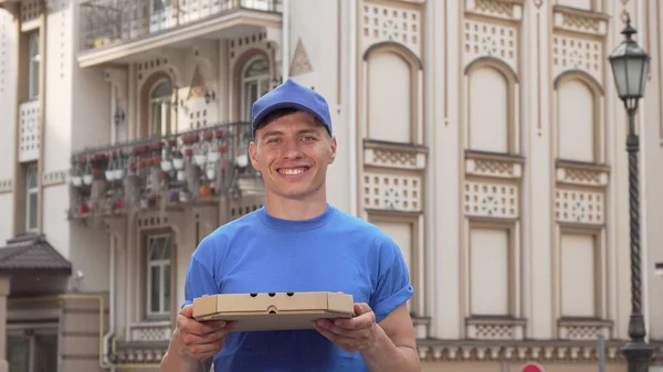 Pizza leverans man Holding pizza Box stående på gatan — Stockfoto