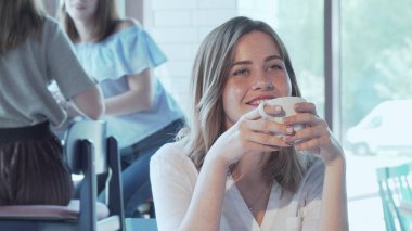 Kafede kahvesinin tadını çıkaran güzel mutlu kadın