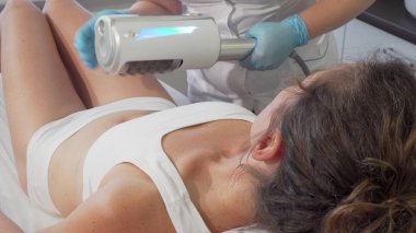 Woman getting  therapy massage on her stomach. Professional beautician reducing belly fat on female client, doing massage. Slimming concept