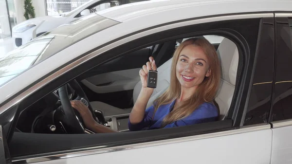 Conductora feliz sonriendo sosteniendo las llaves de su nuevo automóvil — Foto de Stock