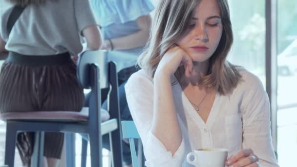 Mujer triste sentada sola en la cafetería — Vídeos de Stock