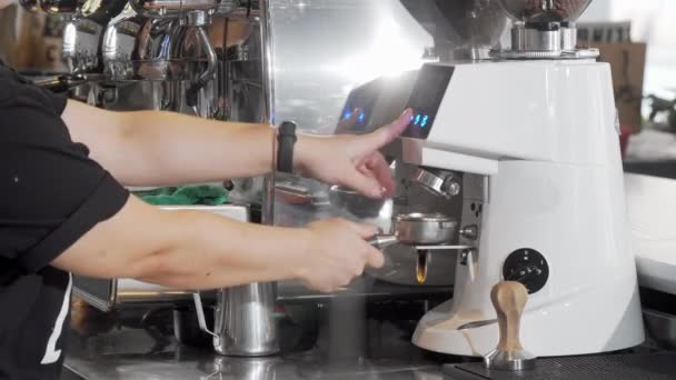 Обрезанный снимок баристы, шлифующей кофейные зерна с помощью кофеварки — стоковое видео