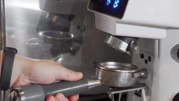 Bijgesneden schot van een barista slijpen koffie in koffiezetapparaat — Stockvideo
