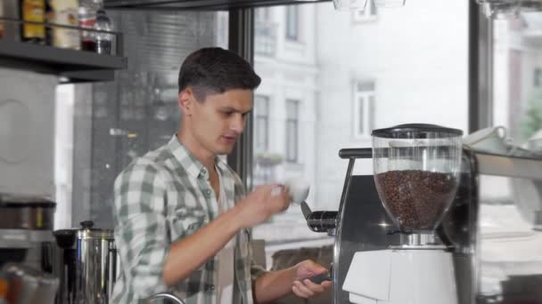 Hezká, veselá mužská Barista, připravující kávu pro klienty ve své kavárně — Stock video