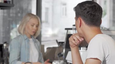 Mutlu adam yerel kafede kahve satın aldıktan sonra kameraya gülümseyen