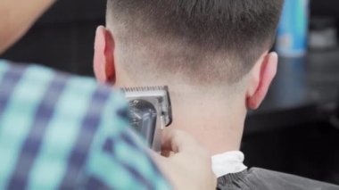 Erkek müşterinin saçını kesen bir berberin arka plan görüntüsü.