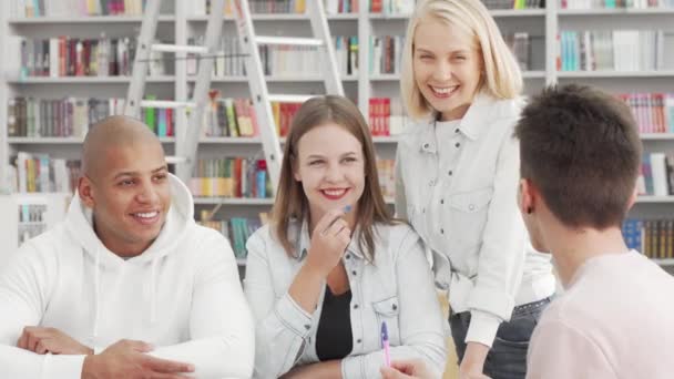 Jeunes gens joyeux qui aiment parler à la bibliothèque du collège après avoir étudié — Video