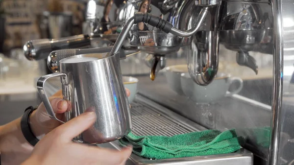 コーヒーショップのお客様のために飲み物を準備する泡立つピッチャーのバリスタ蒸しミルク — ストック写真