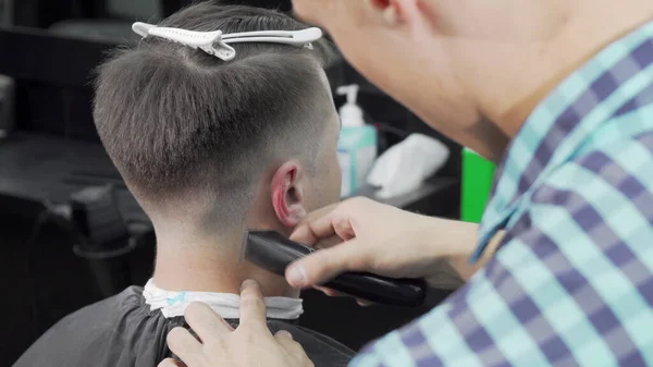 Barbeiro profissional dando um corte de cabelo para um cliente masculino — Fotografia de Stock