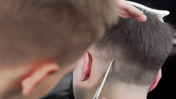 Vista trasera recortada de un peluquero cortando el pelo de un cliente masculino — Foto de Stock