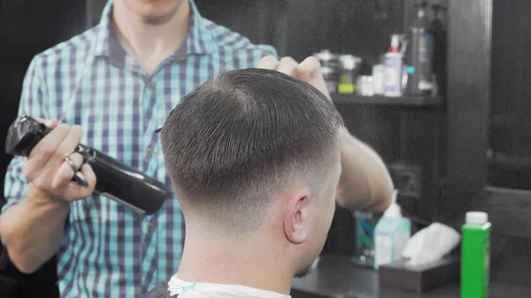 Coiffeur professionnel mouillage et peignage des cheveux d'un client masculin — Photo