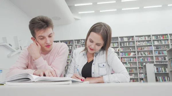 Plan en angle bas de deux amis du collège appréciant d'étudier ensemble à la bibliothèque — Photo