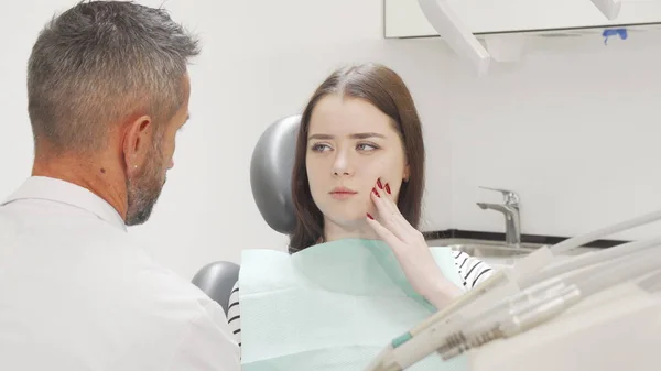 Jovem encantadora com dor de dente visitando seu dentista — Fotografia de Stock