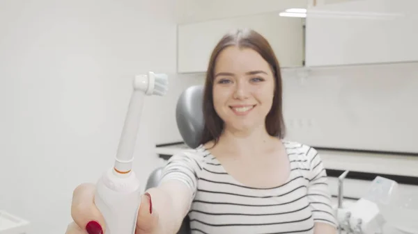 Selectieve focus op elektrische tandenborstel in de handen van een gelukkige vrouw — Stockfoto