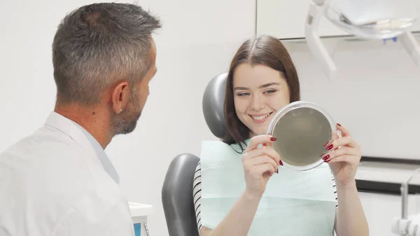 Mulher feliz bonita conversando com o dentista após o check-up médico — Fotografia de Stock