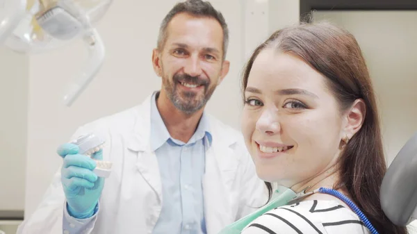 Mulher atraente sorrindo para a câmera durante a consulta com o dentista — Fotografia de Stock