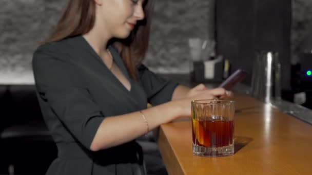 Plan d'une femme prenant un verre à cocktail au comptoir du bar — Video