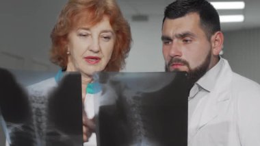 İki doktor hastalarının röntgen taramalarını tartışıyor.