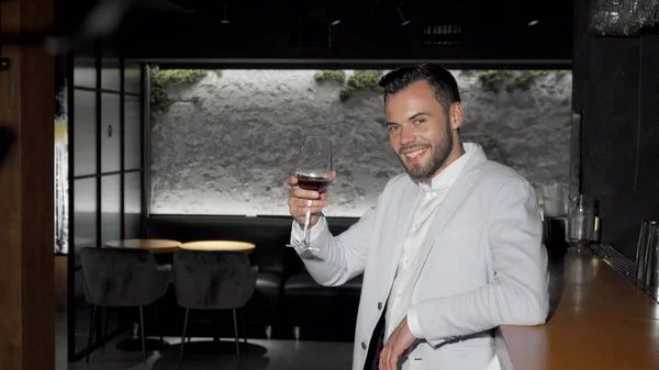 와인 잔을 들고 카메라 앞에서 웃고 있는 행복 한 미남 — 스톡 사진