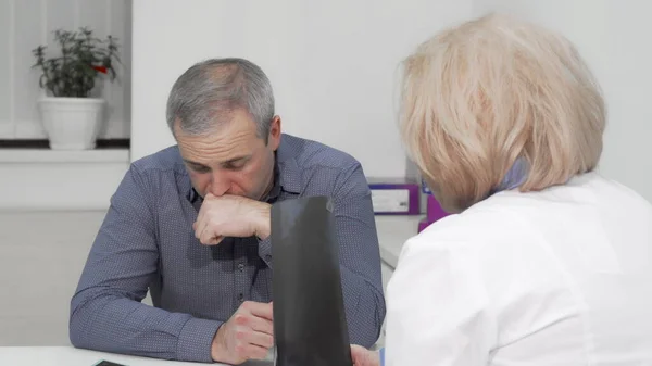 Homem maduro tosse na consulta médica com seu médico — Fotografia de Stock
