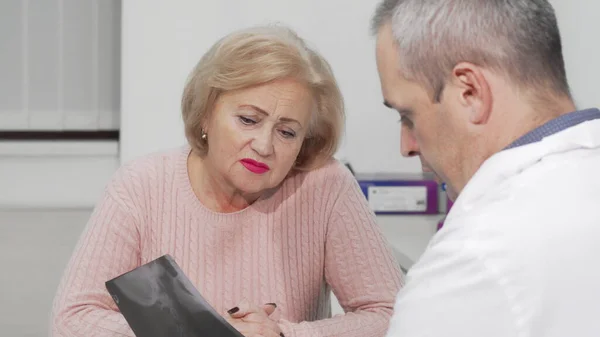 Starsza kobieta otrzymująca złe wieści podczas wizyty u lekarza — Zdjęcie stockowe