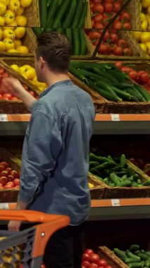 Şık, sarışın bir adam canlı bir süpermarkette taze ürünlerin olduğu bir kaleydoskop içinde gevrek bir Napa lahanasını dikkatlice inceliyor. Renkli sebze ve meyvelerden oluşan gökkuşağıyla çevrelenmiş, sağlıklı yaşam ve bilinçli alışverişe bağlılığını gösteriyor.