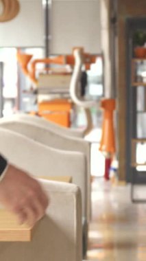 Canlı bir kafe ortamında, iki iyi giyimli erkek iş ortağı sıkı bir tokalaşma içinde, işbirliğine olan bağlılıklarını sembolize ediyorlar. Büyük pencerelerden süzülen doğal ışık ve şık dekorla sıcak ortam davetkar bir hava yaratıyor.