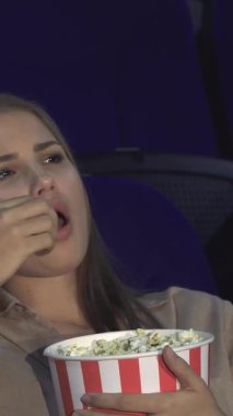 Loş bir sinemada, genç bir çift yan yana oturur ve kızın ifadesi can sıkıntısını ortaya çıkarırken dikkatsiz bir şekilde patlamış mısırı atıştırır. Adam koltuğuna yaslanıyor, gözleri yarı kapalı, sönük bir filmin hayal kırıklığını somutlaştırıyor