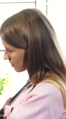 Parlak ve misafirperver bir veteriner kliniğinde şefkatli genç bir veteriner şefkatli bir sarışın kadın tarafından sevgiyle kucaklanan bir Alman porsuk köpeğinin ağzını dikkatle inceliyor. Bu iç açıcı sahne güven ve şefkat yayıyor, derin bağı vurguluyor.