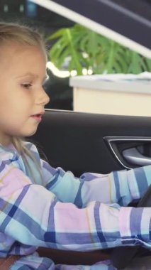 Dalgalı sarı saçlı neşeli küçük bir kız direksiyonda oturmuş anahtarlara uzanırken heyecandan kıvranıyor. Canlı bir menekşe elbise giymiş, neşeli ruhu macera saçıyor, izleyicileri gençlik rüyalarının dünyasına davet ediyor.