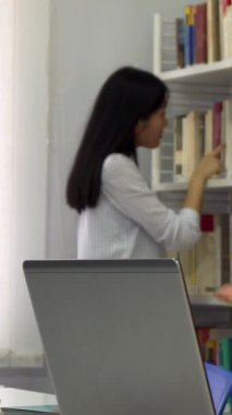 Renkli kitaplarla dolu canlı bir kütüphanede, yakışıklı sakallı bir adam ilginç ama kafası karışmış görünen güzel kahverengi saçlı bir kızla şık bir laptopta bir konuyu tutkuyla tartışırken hareketler yapıyor. Yoğun değişimleri