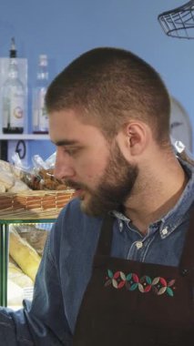 Sıcak ve davetkar bir fırında, şık sakallı çekici bir erkek fırıncı olgun bir bayan müşteriyle yakınlaşıyor, baştan çıkarıcı lezzetli hamur işleri sergiliyor. Dostça etkileşimleri samimiyet ve kişisel bağ yayıyor.