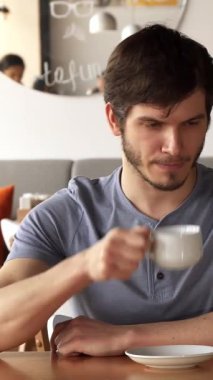 Canlı bir kafe ortamında, yakışıklı beyaz bir adam arkadaşını bekliyor, elinde dumanı tüten bir fincan kahveyle. Atmosfer heyecanla uğulduyor, şık bir Afrikalı Amerikalı kadın neşe saçan bir gülümsemeyle yaklaşıyor, kahkahaları paylaşmaya hazır ve