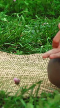 Genç bir kız, doğal sükunetle çevrili canlı yeşil bir çim paspası üzerinde yoga pozları veriyor. Onun odaklanmış el hareketleri ve sakin ifadesi huzur ve farkındalık yayıyor, bu huzurlu ve rahatlatıcı duyguyu davet ediyor.