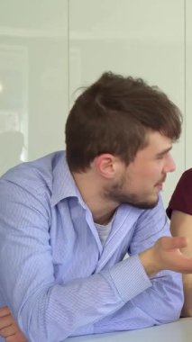 Gösterişli, güneşli bir ofiste, üç genç profesyonel dizüstü bilgisayarın etrafında ateşli bir tartışmaya girişiyor, yaratıcılık ve takım çalışması yayıyorlar. Yakışıklı esmer adam hareketli bir işaretle işaret ederken, dikkatle kızıl saçlı kadın dikkatle dinliyor.