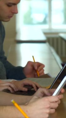 Genç yetişkinlerden oluşan çeşitli bir grup canlı bir kolej konferans salonuna dalmış, özenle not tuttukları dizüstü bilgisayar ve defterlerin bir karışımını sergiliyorlar. Sahne işbirliği ve konsantrasyonun özünü yakalıyor, kalemler hazır ve nazır.