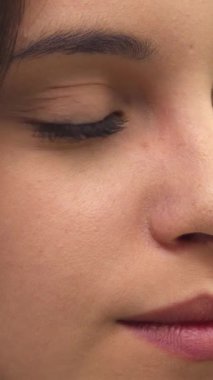 Göz kamaştırıcı beyaz bir kız yüzünü çeviriyor, pırıl pırıl gülüşü kusursuz cildini ve yumuşak özelliklerini aydınlatıyor. Bu yakın plan portre, genç güzelliğinin ve zarafetinin özünü yansıtıyor. Doğal cazibesine ve büyüsüne hayranlık uyandırıyor.