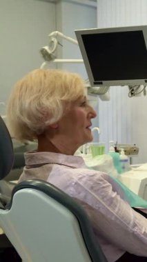 Zarif, modern bir dişçi ofisinde, bakımlı sakallı çekici orta yaşlı bir dişçi, kıdemli bayan müşterisini sıcak bir şekilde selamlıyor. Yumuşak pembe bir bluz giyen yaşlı sarışın kadın, dişçi koltuğuna rahatça oturur, güven yayar ve...