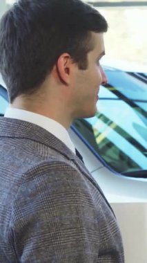 Şık sakallı ve koyu renk saçlı heyecanlı bir adam şık giyimli bir satıcının yeni arabasının anahtarlarını kabul ederken neşe saçıyor. Atmosfer heyecanla uğulduyor. Zafer anı ve yeni başlangıçlar sergiliyor.