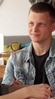 Neşeli bir sarışın adam ve kıvırcık saçlı bir kız şık bir kafede buharlı kahve içerken canlı bir sohbet ederler. Yumuşak ışıklandırma ve çağdaş dekor ile süslenmiş davetkar ambiyans, onların neşeli bağlantılarını güçlendirir, canlı bir ortam yaratır.