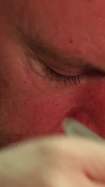 Olgun bir erkek saat tamircisi, çok dikkatli, dağınık çalışma masasındaki hassas bir saat mekanizmasını titizlikle inceliyor. Yakın plan onun yoğun konsantrasyonunu ve yetenekli ellerini yakalar cep saati tacını sarar, sanatını ön plana çıkarır ve...